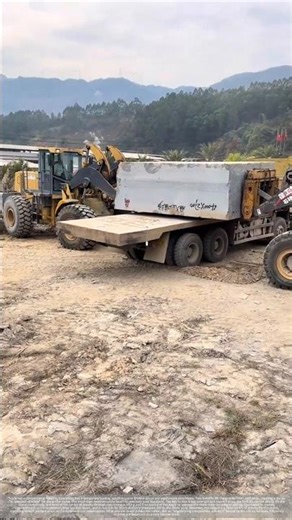 Two forklifts lifted the stones, and the truck backed in from below to load them.