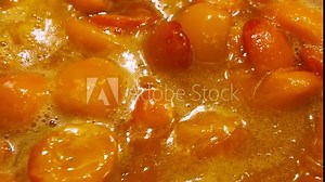 The process of making apricot jam in a metal pan. The jam is cooked in a pan.