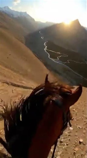 Horseback riding through a dusty mountain landscape at sunrise