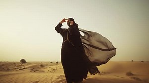 Arab Woman Walking with the long dress in the desert with Nighab