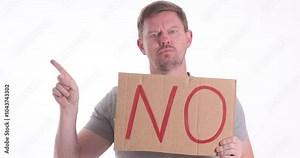 A man confidently holds up a clear NO sign, effectively conveying a strong message of disagreement and refusal