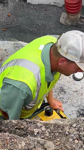 Construction workers wacker packing bedding crushed stone