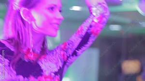 Attractive blond and brunette dancing at club bar, camera flirt