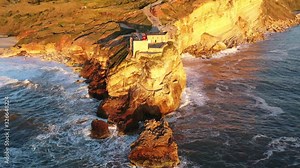 Nazare lighthouse near Praia do Norte Portugal on a sunny afternoon, world record big wave surfing spot, Aerial drone pedestal lift reveal shot
