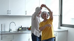 Joyful active old retired romantic couple dancing laughing in living room, happy middle aged wife and elder husband having fun at home, smiling senior family grandparents relaxing bonding together Видео Stock