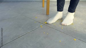 Woman gets up from the table and steps on the crumbs under the table, shakes her feet. Feet close-up.