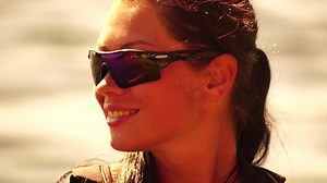 Woman sea kayak. Happy smiling woman in kayak on ocean, paddling with wooden oar. Calm sea water and horizon in background. Active lifestyle at sea. Summer vacation.