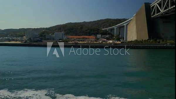 Drone view of the Akashi Kaikyo Ohashi Bridge in Awaji Shima, in Japan with a boat passing in front