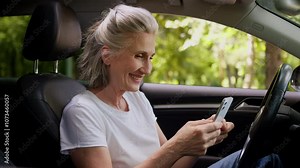 Caucasian smiling elderly aged senior mature woman female old user car driver owner inside automobile vehicle using mobile phone GPS chatting smartphone texting social media online happy client auto
