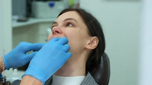 Portrait of woman in dentistry, doctor orthodontist removes silicone teeth trainer from her mouth. Correcting teeth, hands in gloves closeup. Correction of the bite and treatment of the jaw joint.