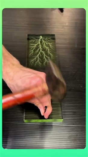 Electric patterns inside resin, branching like lightning as surface reacts in a stunning visual.