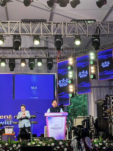 Subhash Phal Dessai, Hon’ble Minister for Empowerment of Persons with Disabilities, Government of Goa, addressing the gathering at the closing ceremony of International Purple Fest. Video description: The hon’ble minister stands on the stage with bright background lights and speaks behind the podiu | EnAble India | Facebook