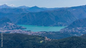 Time lapse, Aerial view on a lake and valley surrounded by mountains. Clouds shadows pass over mountains. Locarno, Lake Locarno, Canton Ticino, Switzerland.