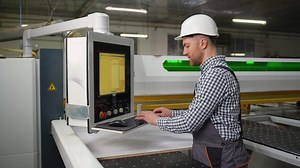Operator Programs CNC Machine for Wood Panel Cutting
