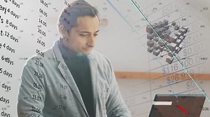 The idea of the planning process and the work on the task. The man is concentrated at the computer on the task. Visualization of calendar diagrams and estimates with a structure of cubes
