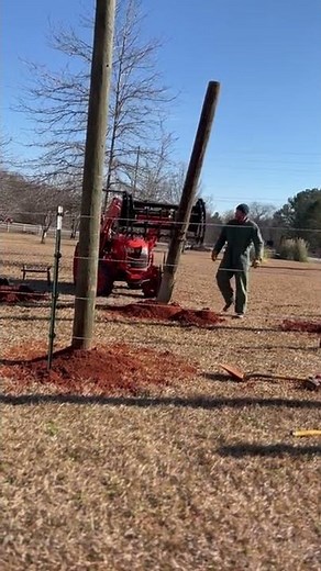 Kubota placing telephone poles for pole barn