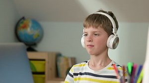 clip-1072632191-boy-sitting-laptop-home-online-lesson-child