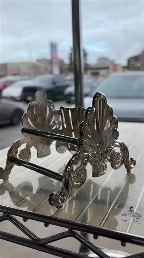 The ends are shaped like scalloped shells or fleur-de-lis crests, with soft ribbing that fans outward like a decorative plume. Along the base, you have elegant scrollwork that curls into delicate spirals, finished with tiny rosette accents that feel very romantic and old-world. #thriftfinds #silverplated #thrift #baroque #victorianera