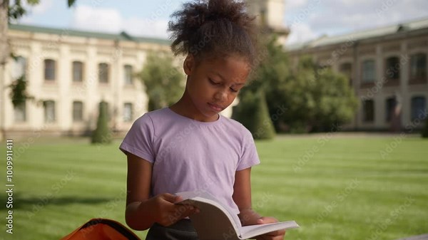 African American little girl pupil student child kid daughter female schoolgirl prepare exam homework learning lesson outdoors read book copybook elementary education school academy studying thinking