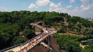 Download Aerial view of Kyiv pedestrian bridge over street traffic and view of city of Kyiv Ukraine