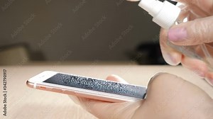 Phone disinfection against dangerous corona viruses and bacteria. Close-up shot of female hand in protective gloves using wet wipe and sanitizer to clean cell phone screen. Female hands holding Stock Video