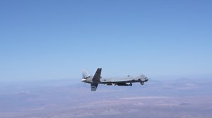 MQ-9 flying, firing Hellfire missiles