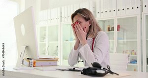 Sad woman doctor looking into computer screen and seeing bad result of analysis of patient in clinic 4k movie slow motion. Problems of telemedicine concept