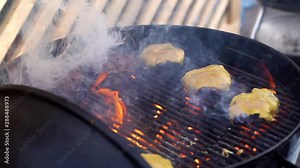 Cooking burger with cheese on open fire close-up in the fresh air. Grilled beef for hamburgers grilled on the pan and put the cheese on top. Meat for burgers is grilled on the grill and cheese.