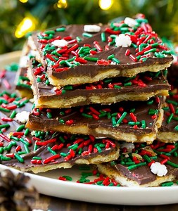 Christmas crack! 🥰Christmas Crack recipe🥰.... Ingredients.... 1 cup packed brown sugar 2 sticks butter About 1 1/4 packages of saltine crackers 1 package chocolate chips Directions..... In a medium saucepan melt butter then add brown sugar(mix well)and bring to a boil for 3-5min. Set it to the side. Line cookie sheet with aluminum foil and spray with cooking spray. Lay crackers on pan then pour and spread mixture over crackers. Place in oven @ 350° for 5 min. Remove from oven and sprinkle choc