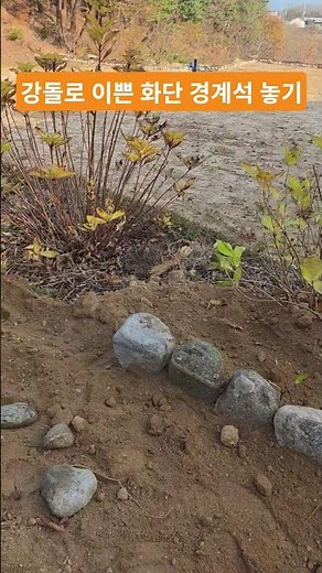 Laying a pretty flower bed boundary stone with river stones