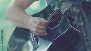 Slow motion. Close-up of guitar playing. Guitarist hits the strings of the guitar. Skill. Playing a musical instrument. Stringed Musical Instruments. Black guitar with abrasions. Old Guitar.