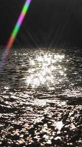 Sparkling sunlight reflecting on rippling water surface creating a mesmerizing and tranquil visual effect, capturing the beauty and serenity of nature