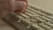 Close up shot of male hand typing on a old beaten keyboard
