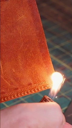 Burning the loose thread and cleaning up the edges — locking it in with a clean finish.