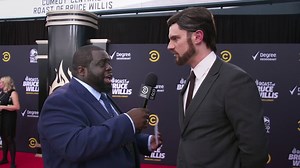 Chris Cotton asks “Hans Gruber” (Flula Borg) to explain some of the plot holes in Die Hard. | Roasted