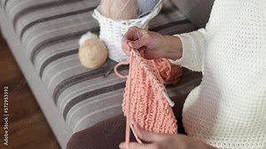 Close-up of woman's hands knitting a woolen scarf. A woman knits from thick yarn. A woman is engaged in her hobbies. Knitting concept Stock Video