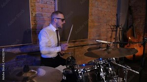 Man playing drums. Rock band playing in the studio. Funny musicians. Cool virtuoso drummer.
