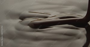 Closeup footage of pouring melted chocolate syrup, in bright light, with blur background