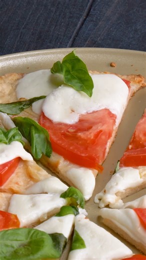 Fresh mozzarella and garlicky dough make this Caprese pizza a standout for summer dinners or easy entertaining! Find the full recipe here: bit.ly/3JkjTBn | Taste of Home