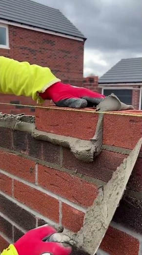 the process of installing red bricks in construction