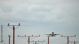 Commercial airliner takes off from airport runway and flies overhead. Front view passenger airplane in sky. Jet aircraft takes off and gains altitude. Flight directly to camera, slow motion