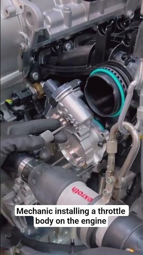 Mechanic installing a throttle body on the engine