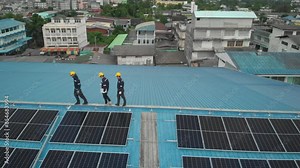 Aerial view of engineer worker having accident by walk while checking on solar cell panels installed on roof of the factory with professional team. Electric power industry renewable energy.