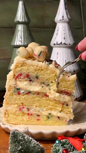 Sugar Cookie Cake! This cake is a mix between sugar cookies and a soft cake! It has vanilla cake layers with sugar cookie dough baked in, edible sugar cookie dough in the filling with cream cheese frosting. #sugarcookiecake #sugarcookie #christmascake | Stephanie's Sweet Treats