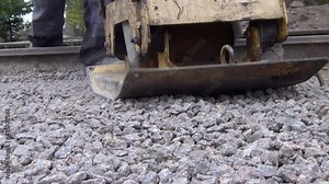 workers tamp crushed stone using a vibratory plate vibratory rammer. High quality FullHD footage