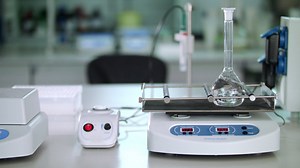 Laboratory equipment in modern lab. Pure liquid mixing in glass flask | Premium Stock Video Footage