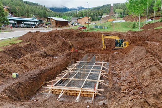 The foundation for the new frontside lift’s bottom terminal is starting to take shape, and that other big hole? It’s where the concrete base for the first lift tower will soon be installed! | Angel Fire Resort