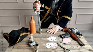 A footage of a pirate playing cards and doing tricks on a rough wooden table