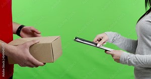Woman receiving and signing package from mailman