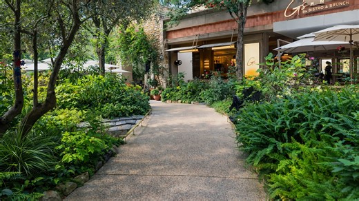 Πράσινη διαδρομή ανάμεσα σε κήπο και χώρο εστίασης